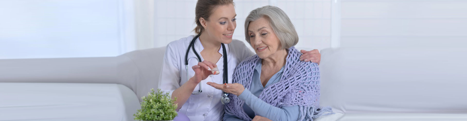 nurse giving senior woman medicine